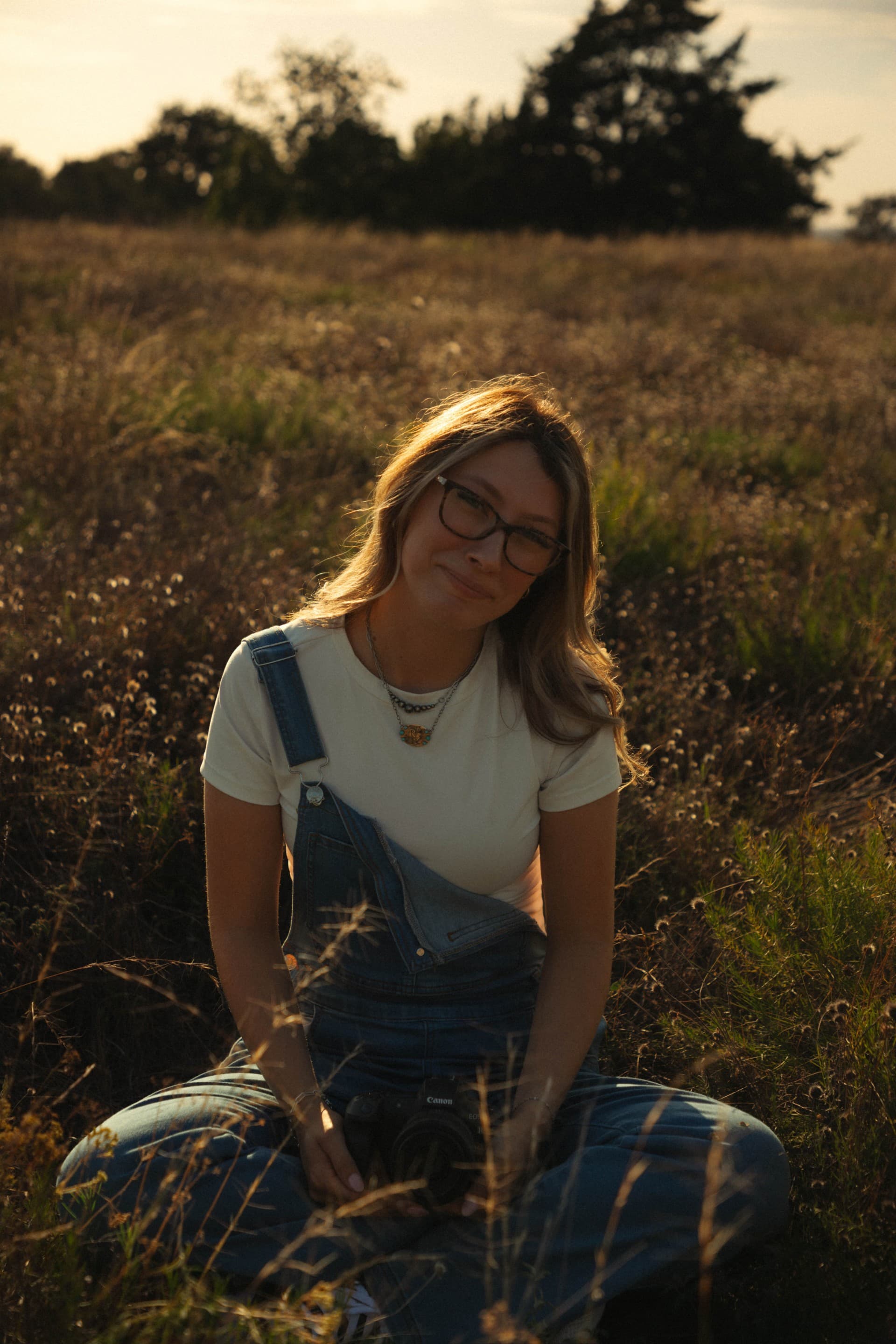Rachel Skaggs seated in a field in warm evening light.